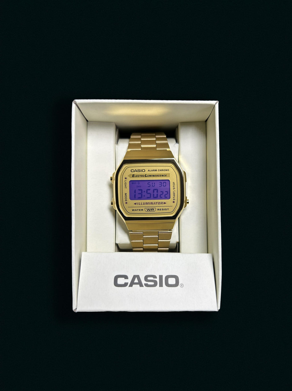 Gold-tone Casio A168 with purple display presented in its Casio box