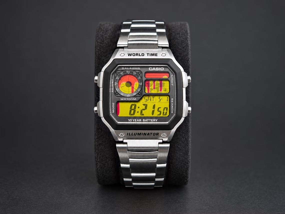 Custom Casio AE-1200 with abstract red-drip artwork on a yellow display and stainless-steel bracelet