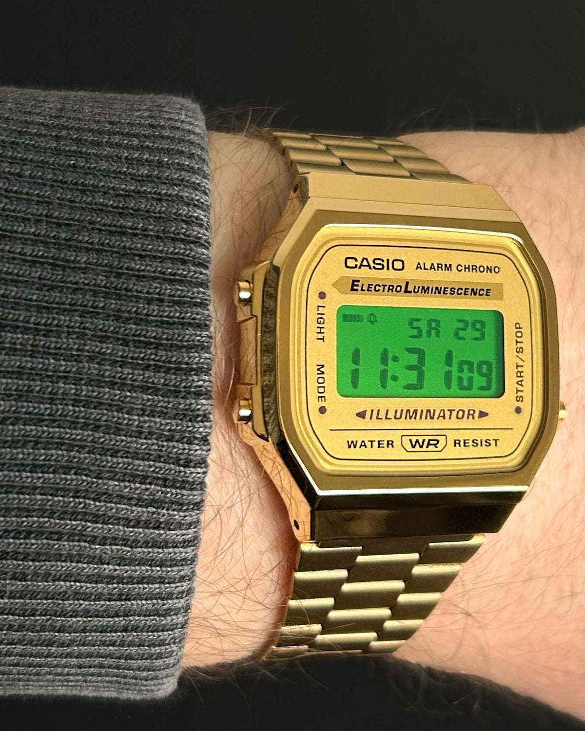 Gold-tone custom Casio A168 with green display worn on a wrist