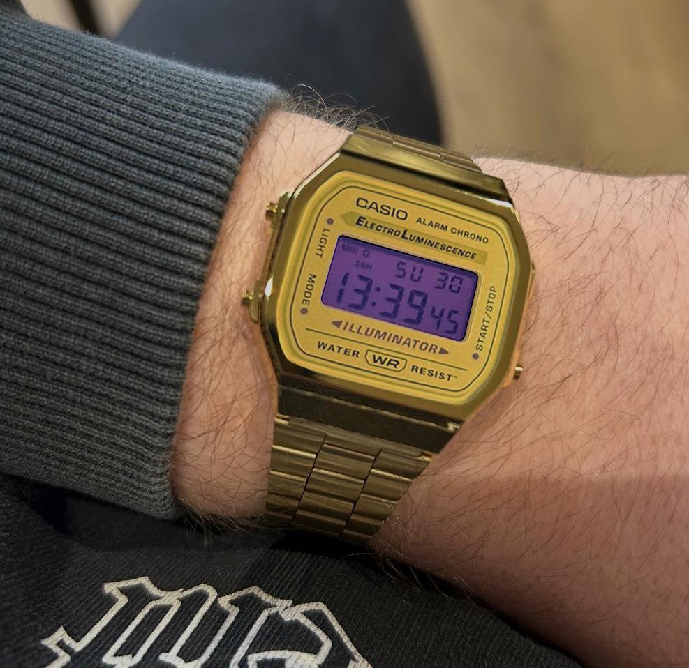Gold-tone custom Casio A168 with purple display worn on a wrist