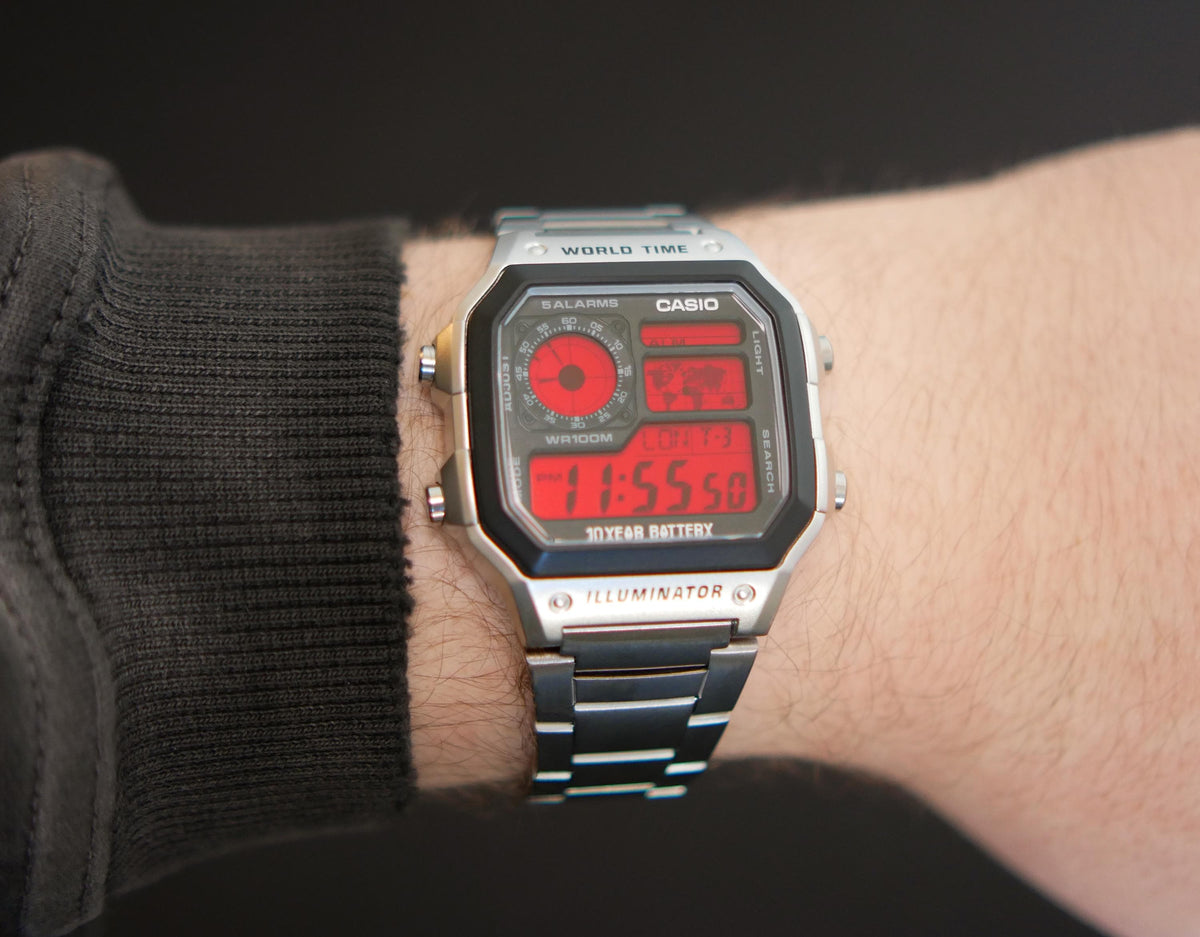 Custom Casio AE-1200 red display watch with stainless-steel bracelet worn on a wrist